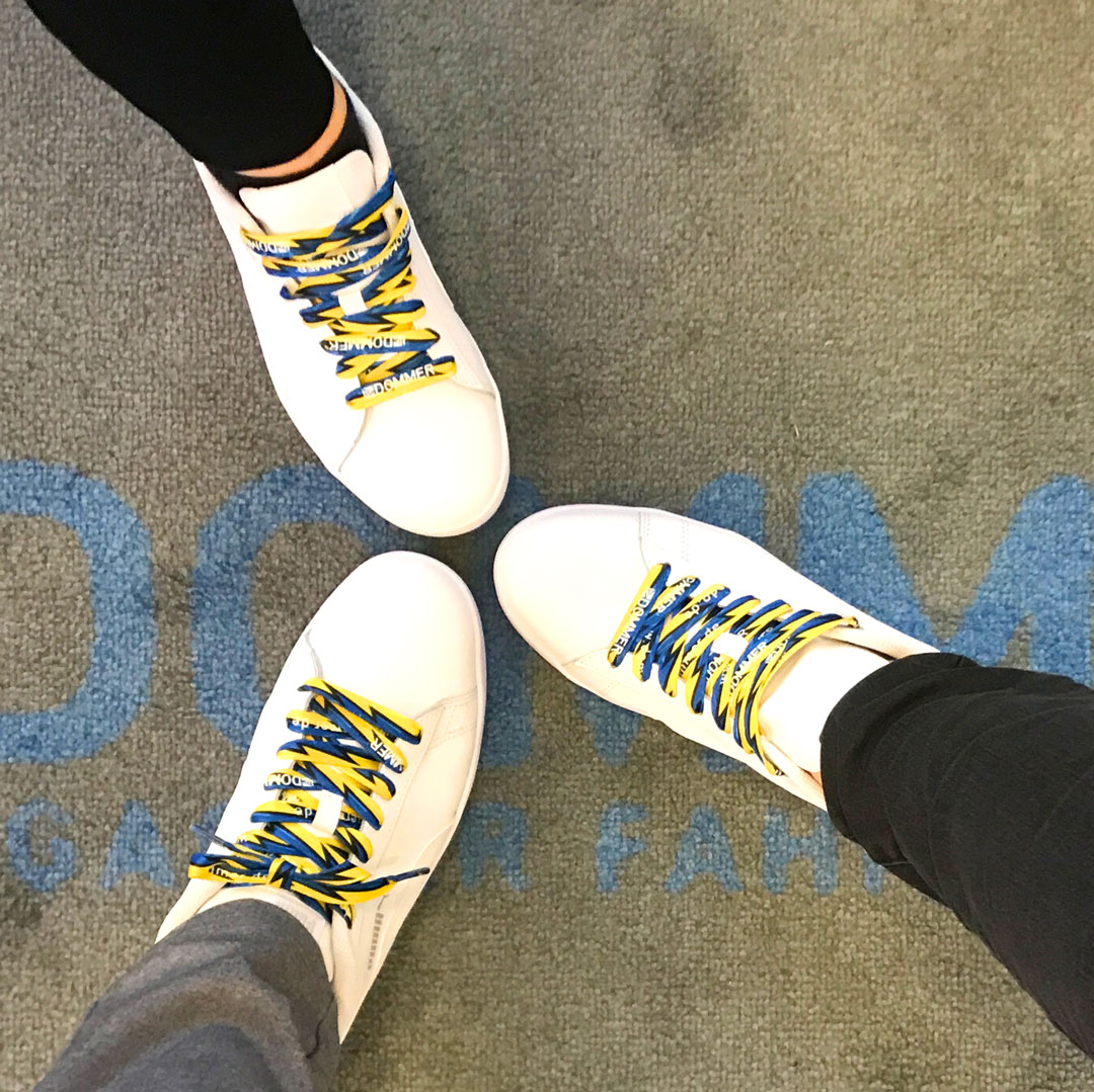 Drei weiße Schuhe mit bedruckten Schnürsenkeln