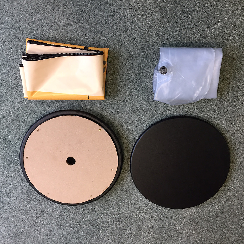 Einzelteile des Airquick Tisches: gefaltete Bespannung, aufblasbarer Kern und runden Tischplatte